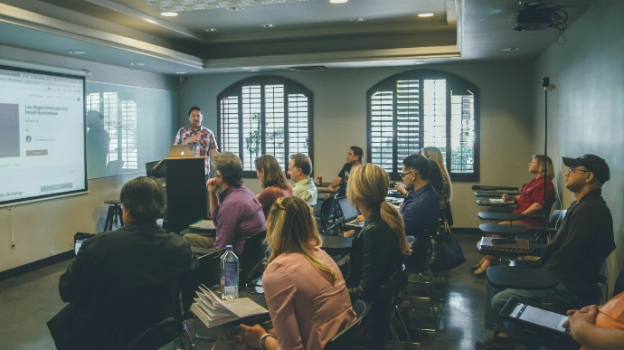 a group of people in a room with a projector screen