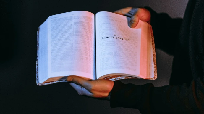 person holding book showing Nuevo Testamento